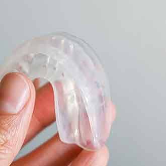 Patient holding clear mouthguard